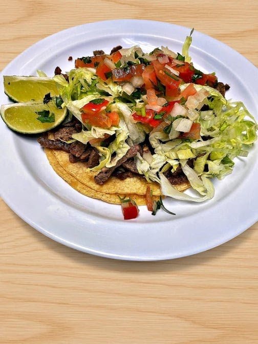 Menu board with breakfast burritos and tacos.