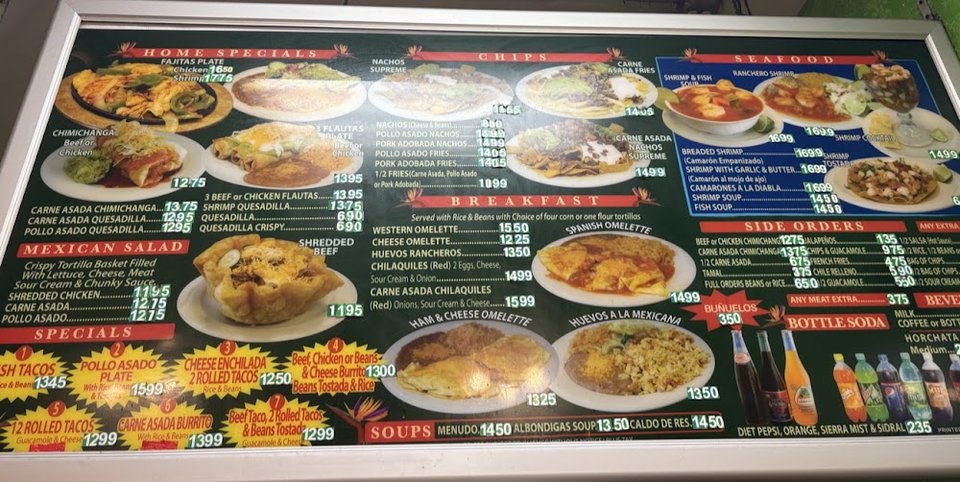 Menu board with breakfast burritos and tacos.